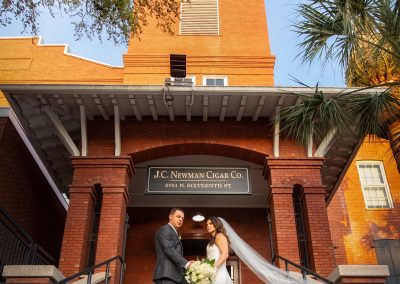 bride and groom in front of JC Newman Cigar Co