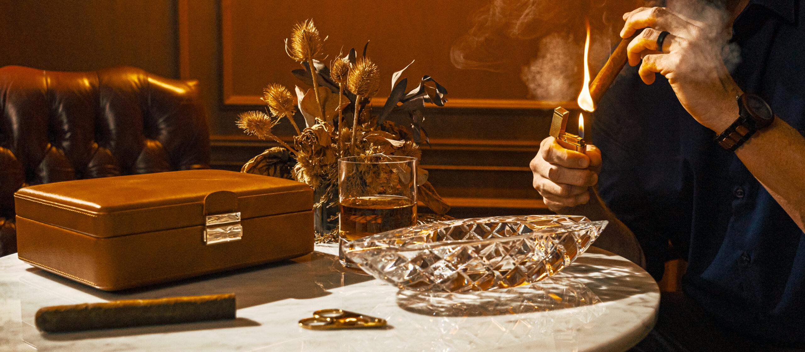 Man sitting at a table and lighting a cigar 